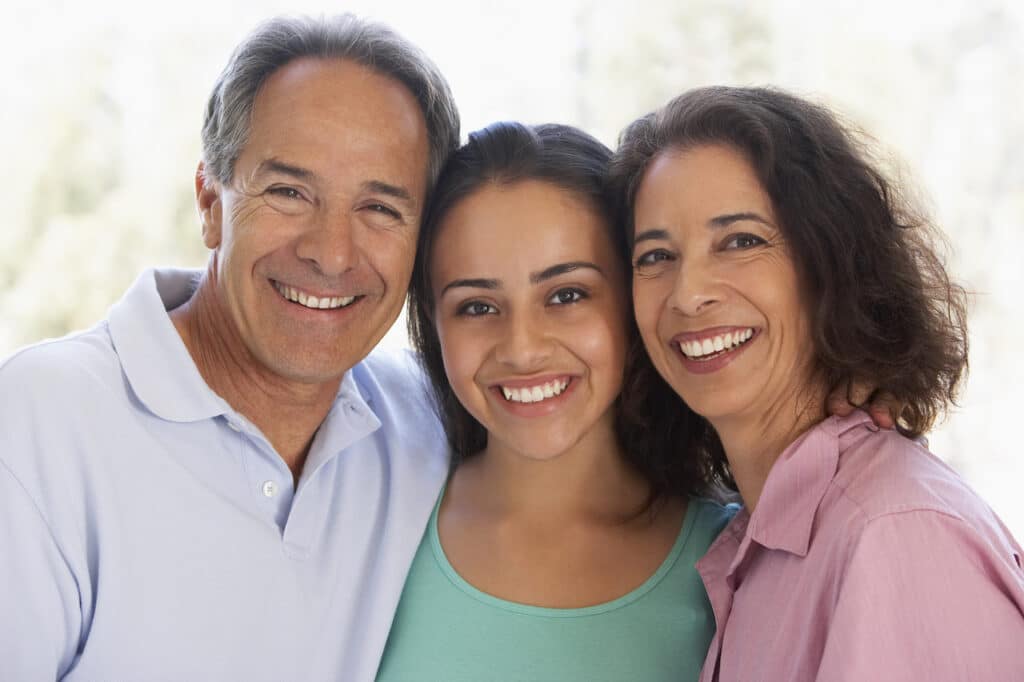 hispanic teen with her parents smiling