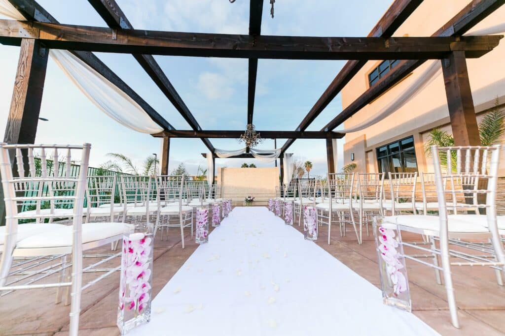 flowers and chairs line wedding aisle outside