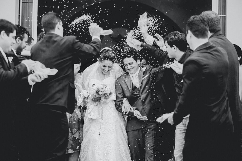 guests throwing rice at couple leaving 