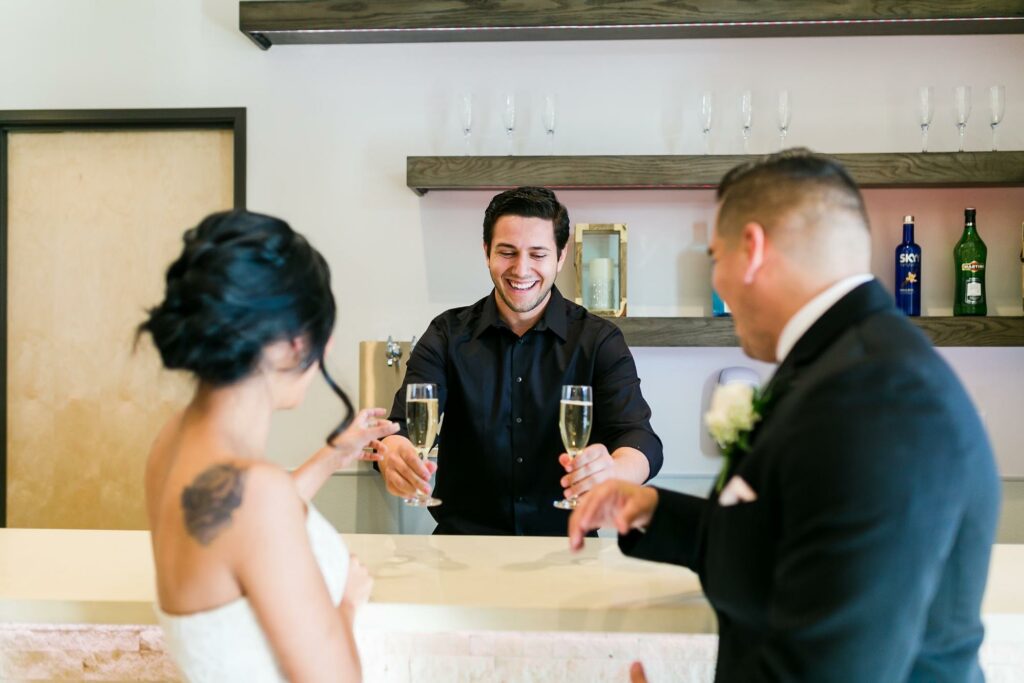 bartender serving drinks to bride and groom