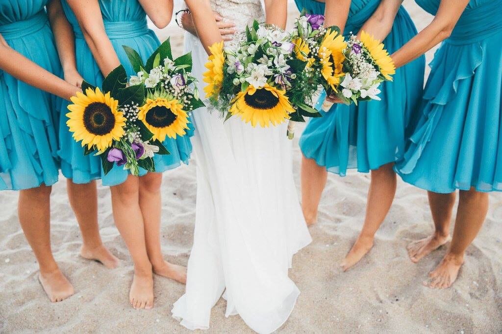 bride and bridesmaids holding sunflower bouquets
