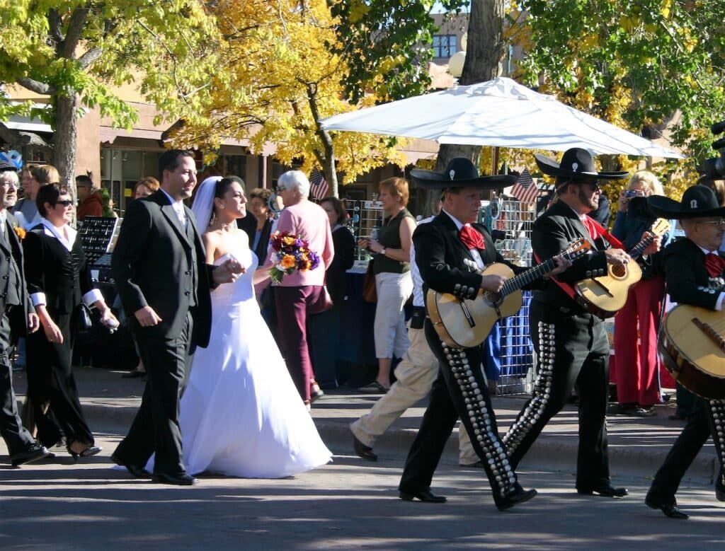 Bride and groom walking in a parade.