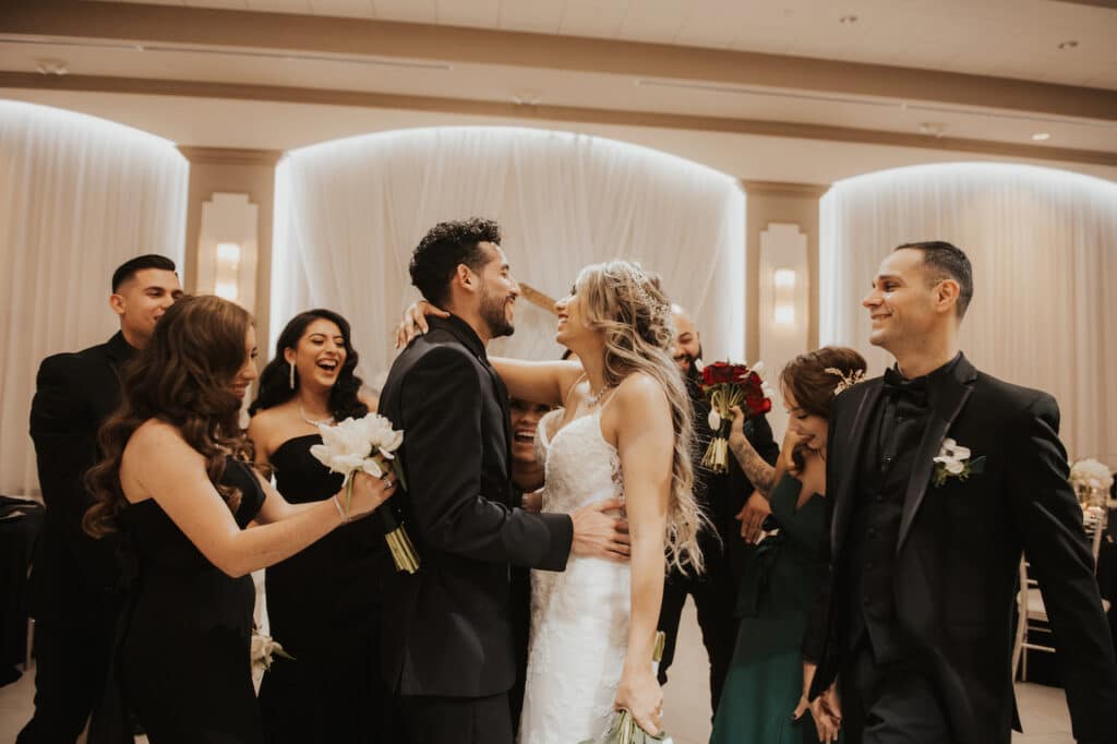 Bride and groom surrounded by people.