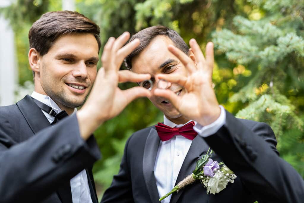 gay couple holding up wedding rings