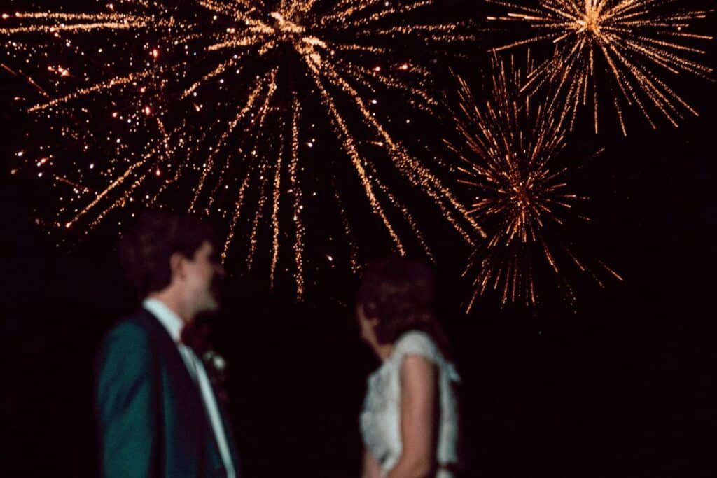 Bride and Groom standing under firework explosion.