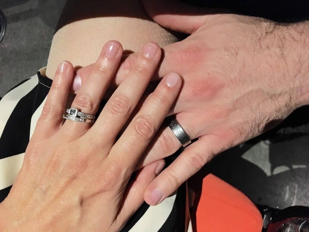 couples hands wearing wedding bands
