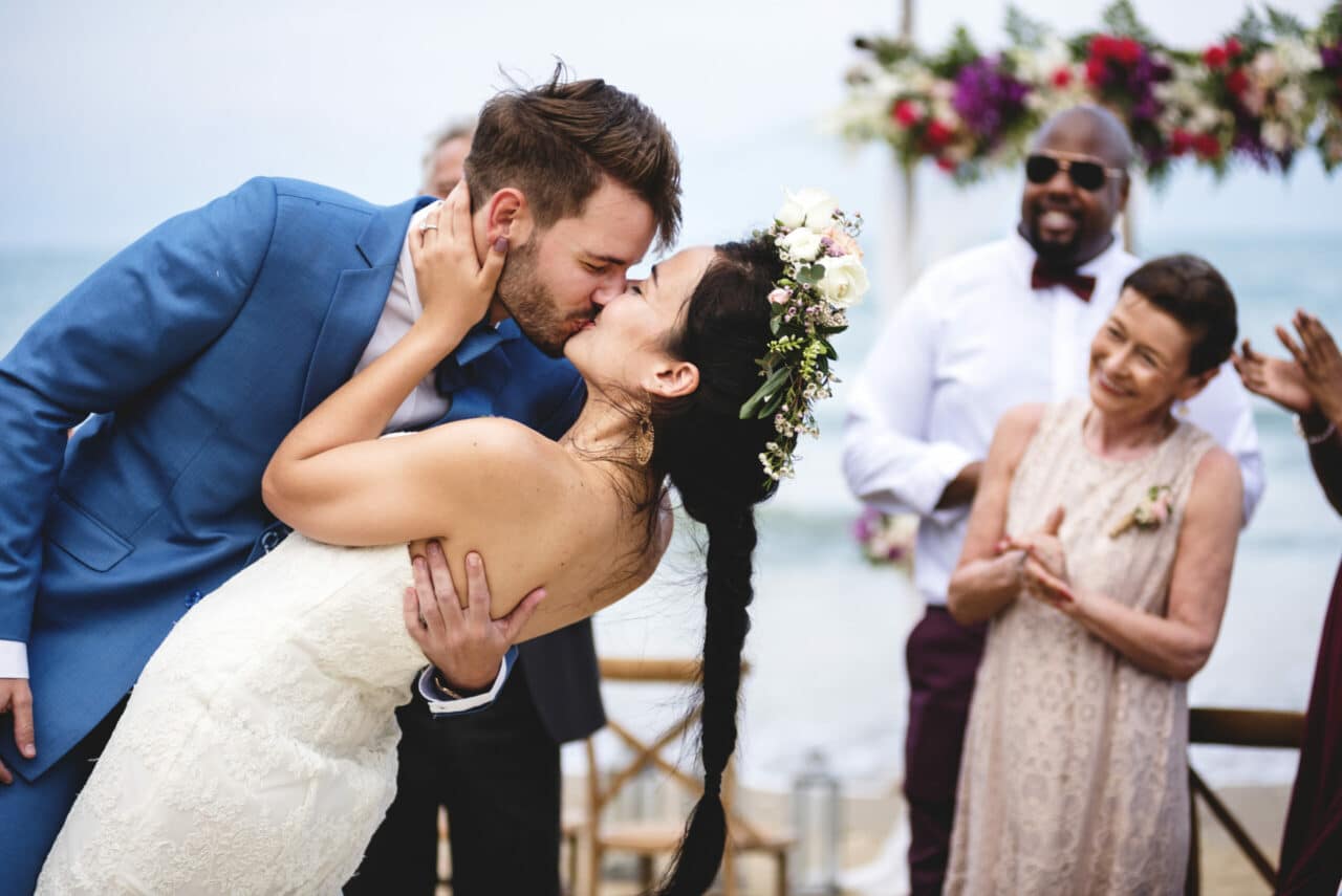 Wedding couple kissing at beach wedding