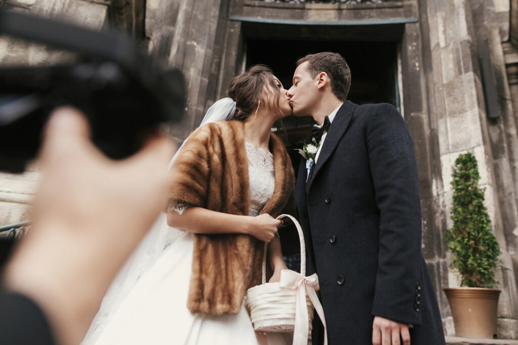 December bride and groom kissing outside