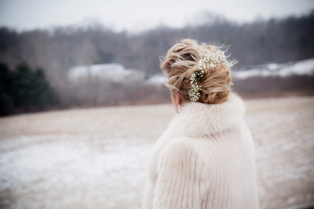 December bride looking out at wintry landscape