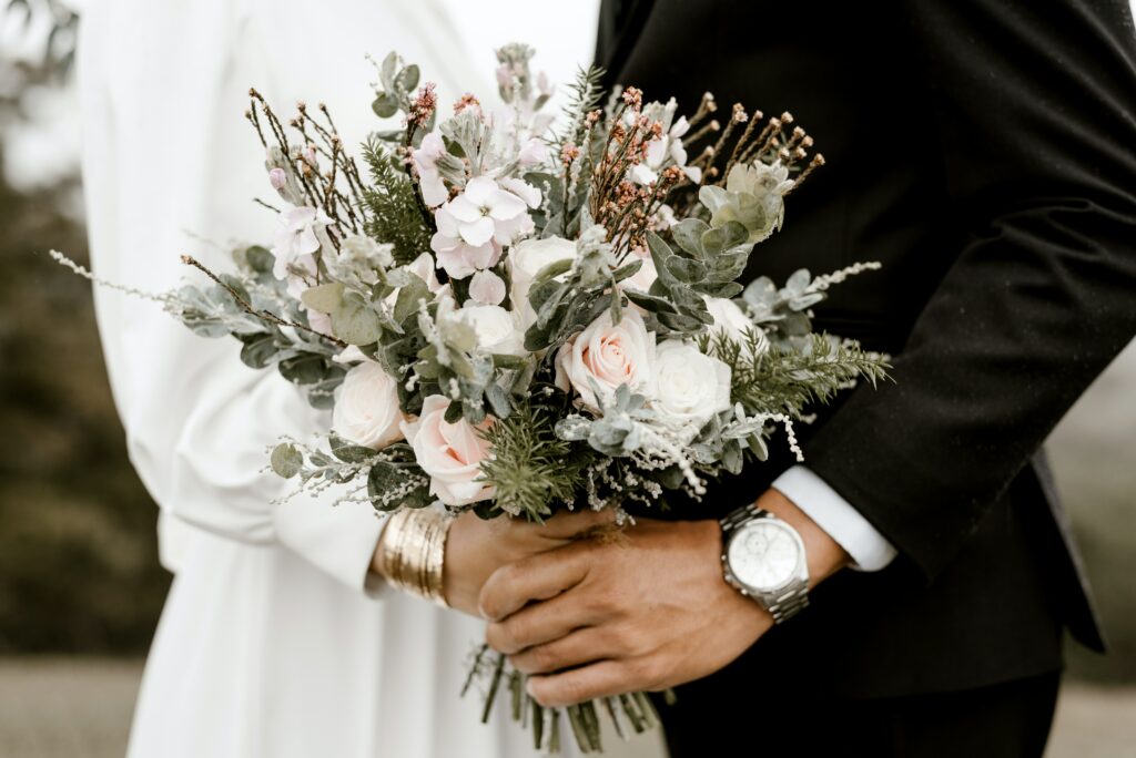 photo of wedding couple holding bouquet together