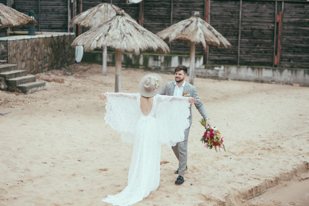 beautiful happy bridal couple in bohemian style on beach