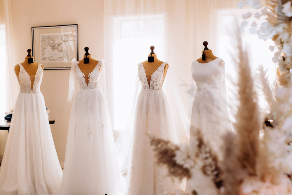 beautiful white wedding dresses hang on mannequins