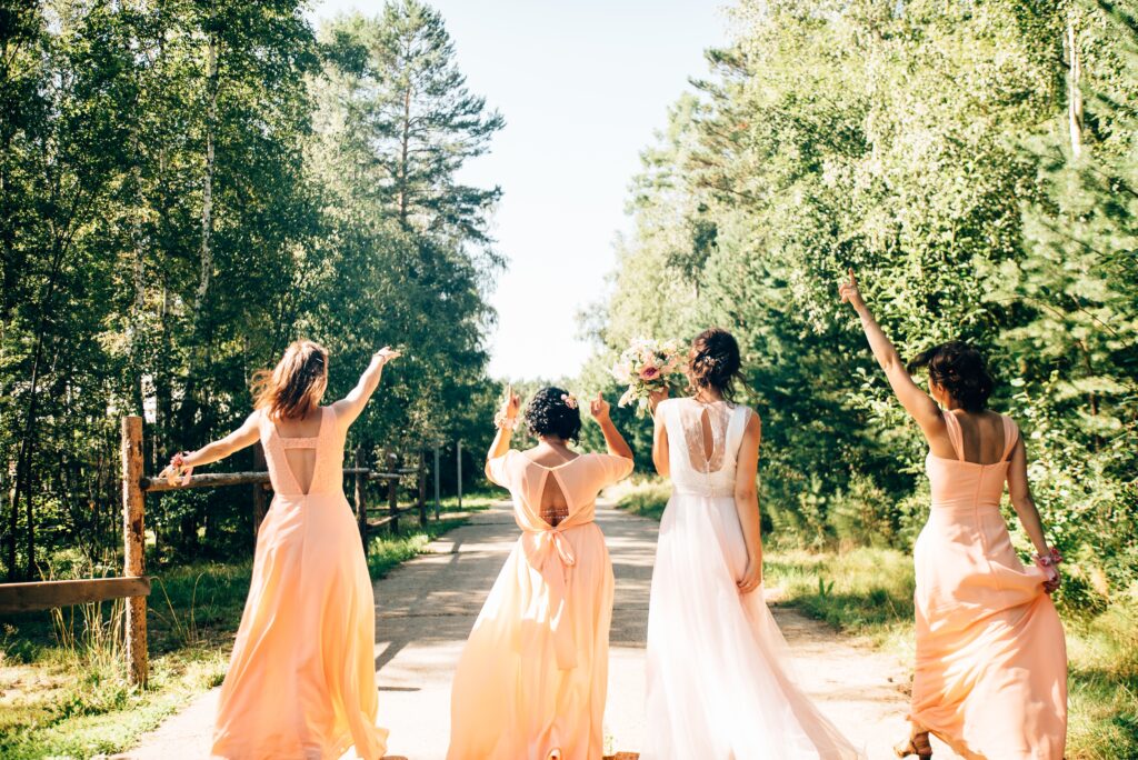 bride with bridesmaids walking down path