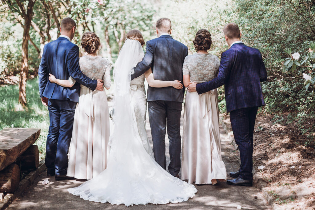 bride and groom on nature path with wedding party