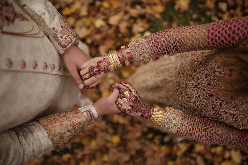 Indian bride and groom holding hands in traditional wedding attire