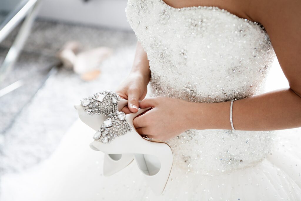 close up of a bride holding her wedding shoes