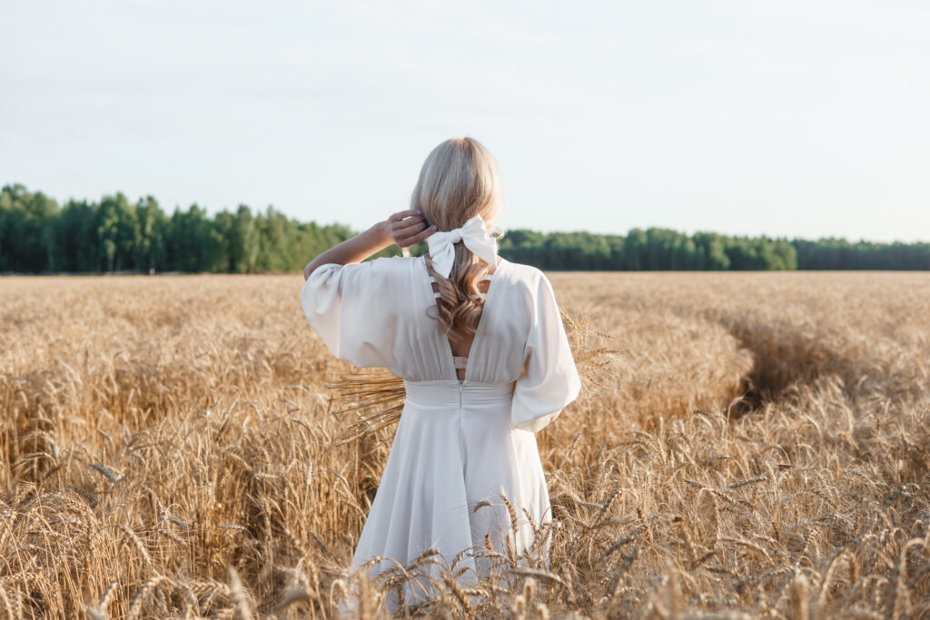 blonde bride walks in a wheat field