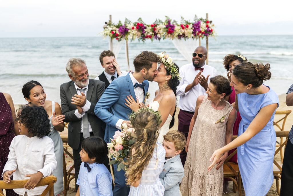 bride and groom kiss at beach wedding
