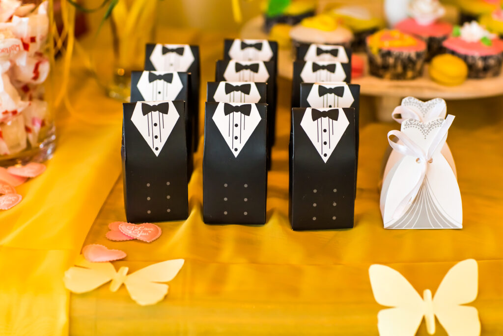 Miniature wedding party favors in the shape of a suit and dress