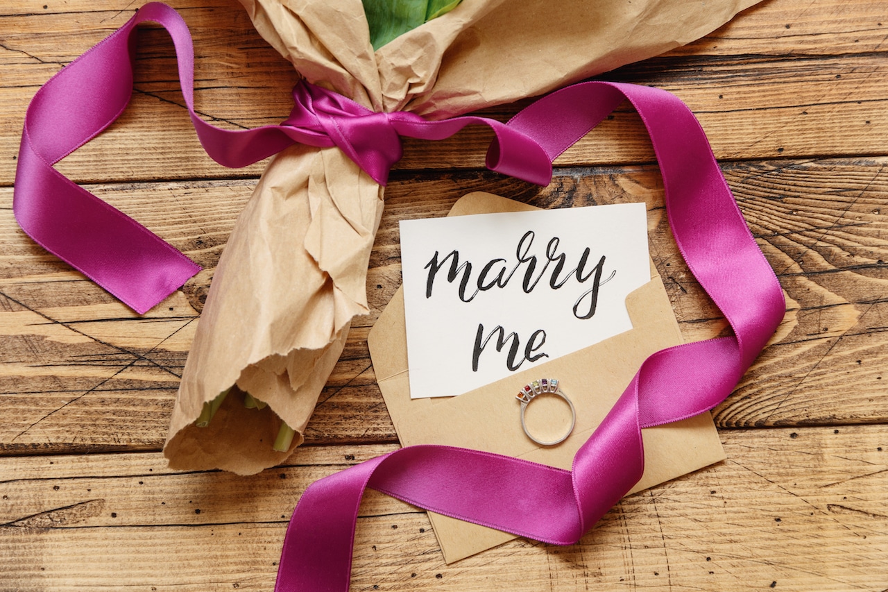 marry me card and wedding ring being unwrapped