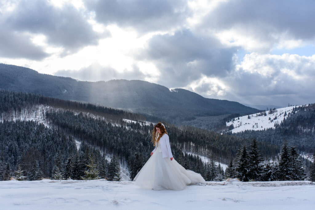 beautiful bride walking in the snowy mountains