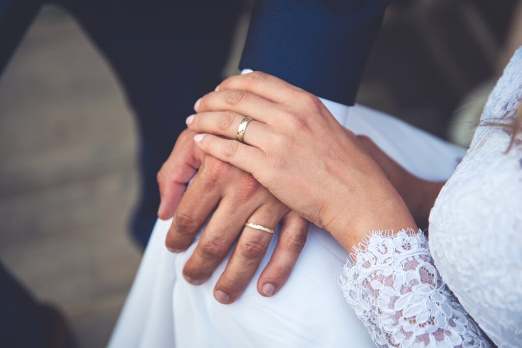 close up of bride and groom's ring hands