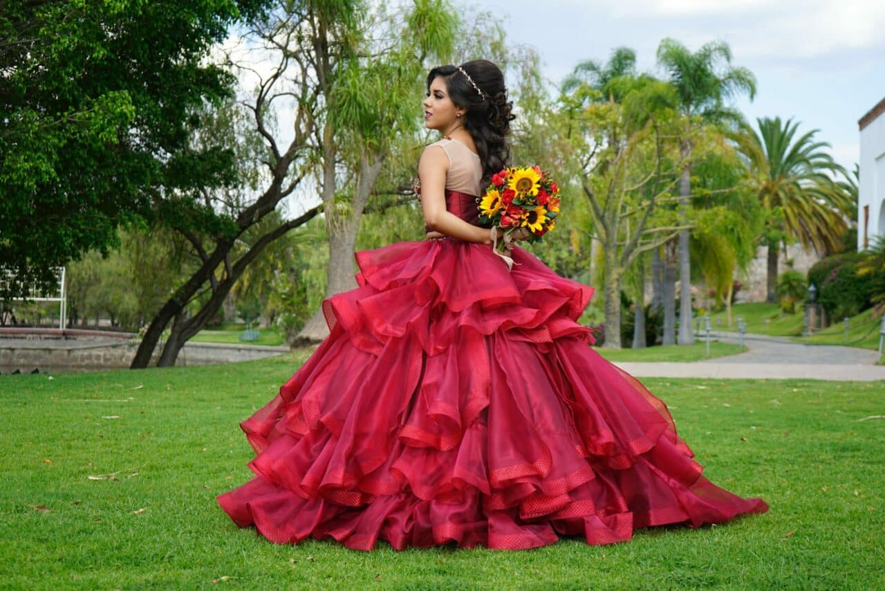 girl standing in red quinceanera dress
