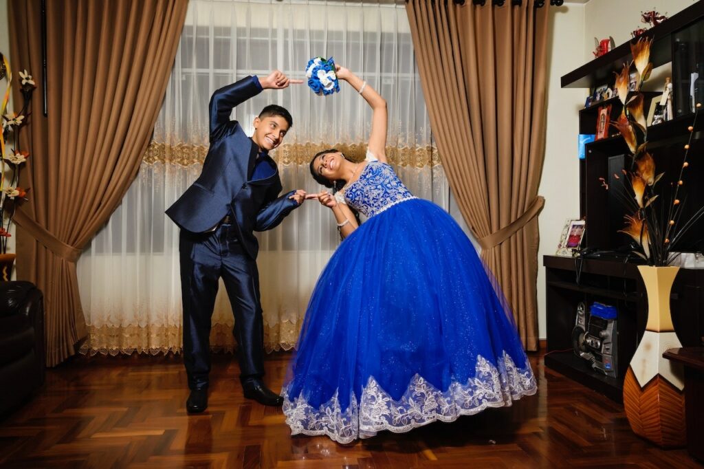 girl striking a silly pose with friend at quinceañera