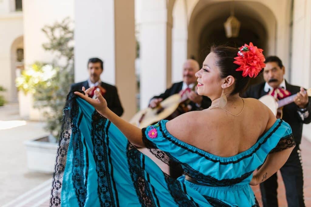 woman in traditional dress dancing with mariachi band