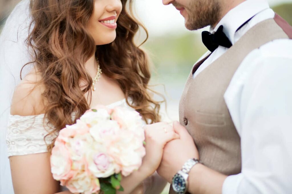 groom and bride holding bouquet of tiny roses