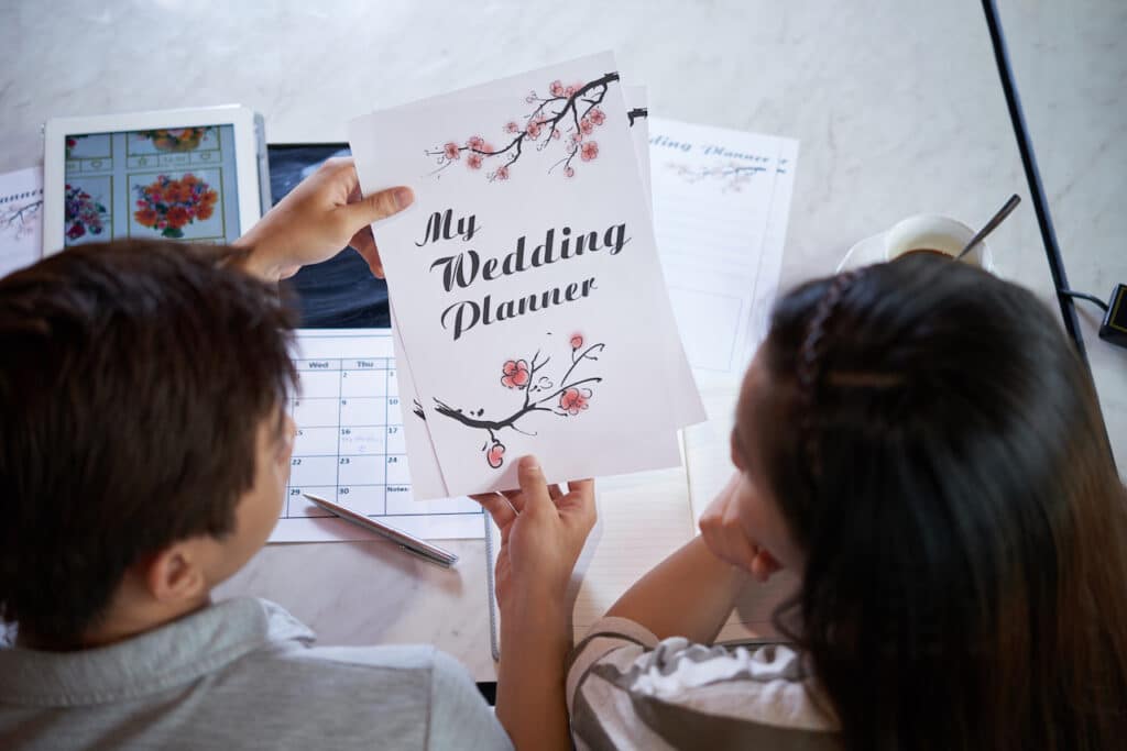 couple working on wedding planning document