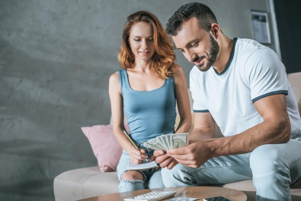 couple at home planning family budget on the couch