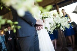 Close up of bride and groom holding hands at a wedding ceremony