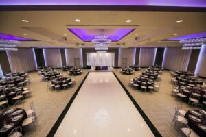 marinaj banquet hall with tables set up with dining ware and dance floor in the middle of room