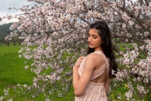 girl next to tree wearing pink dress for quince
