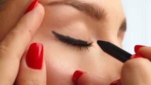 closeup of woman applying winged eyeliner to eyes