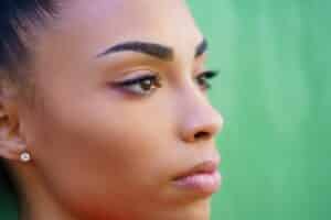 closeup of young woman with bold eyebrows looking away from camera