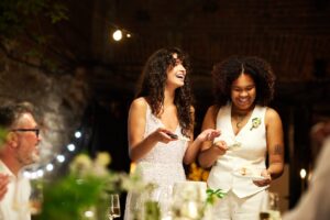 Cheerful young progressive couple in white wedding attire laughing