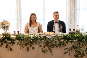 bride and groom sitting at head table at reception