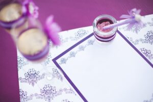 lilac quinceanera invitation with pen next to it