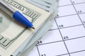 pen, money, and calendar on table