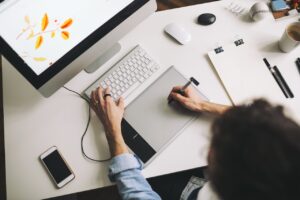 Modern designer sitting in front of computer and working