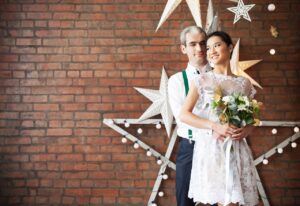 Cheerful married couple near a brick wall decorated with the stars