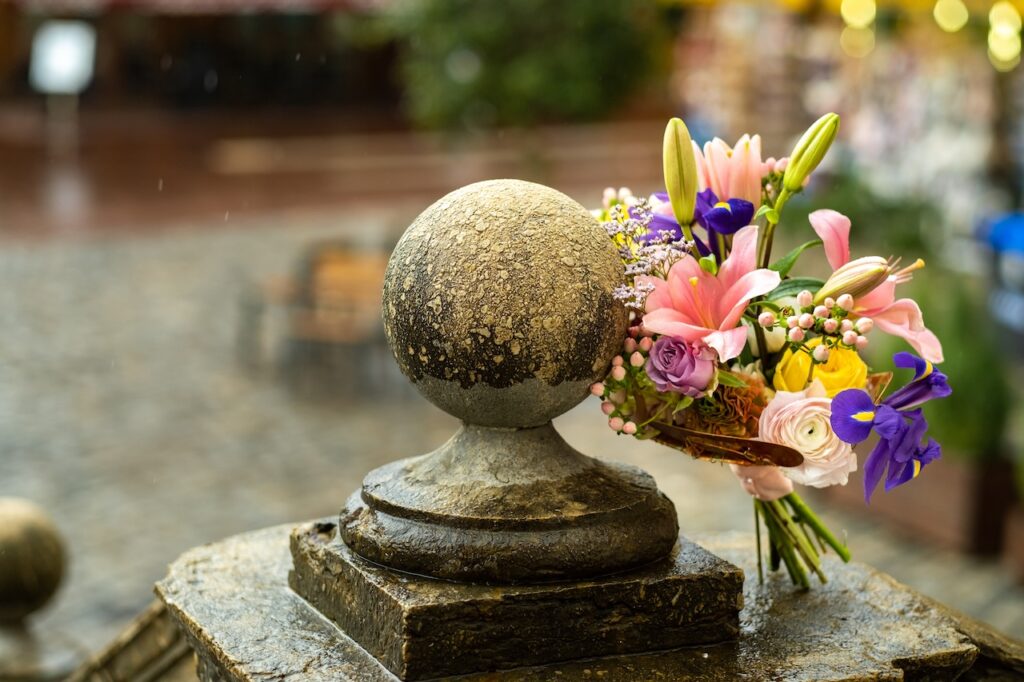 flower bouquet next to small memorial statue