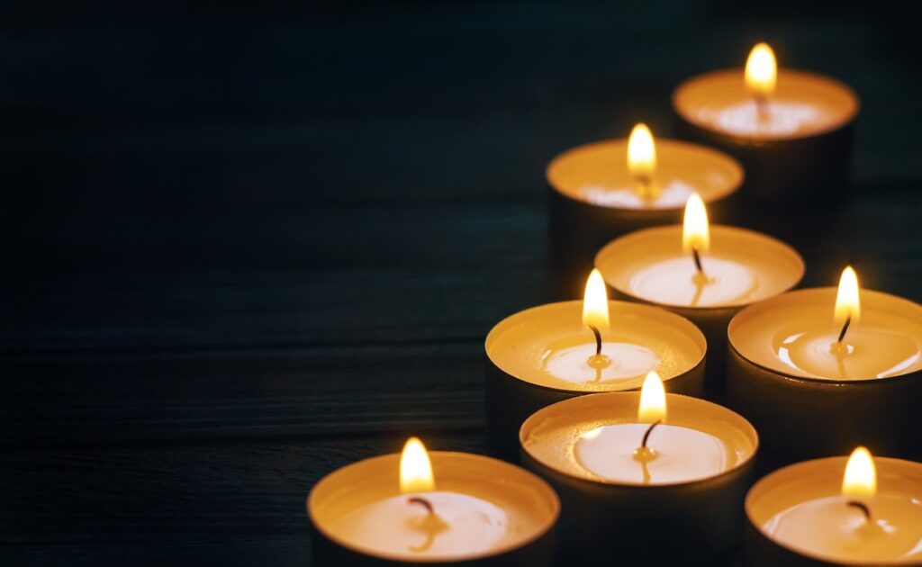 group of small lit candles in the dark