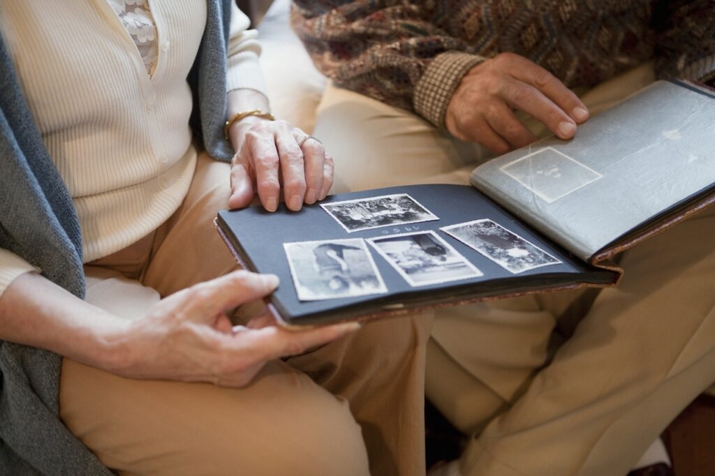 two adults looking at memory book of photos
