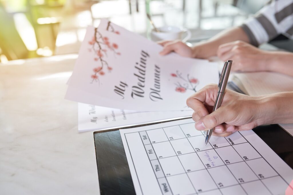 two ladies writing on wedding planner and calendar